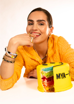 Mannequin qui mange un gateau jaune en forme de smiley